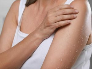 Woman wiping Pristine Body Cleansing Spray onto skin to clean